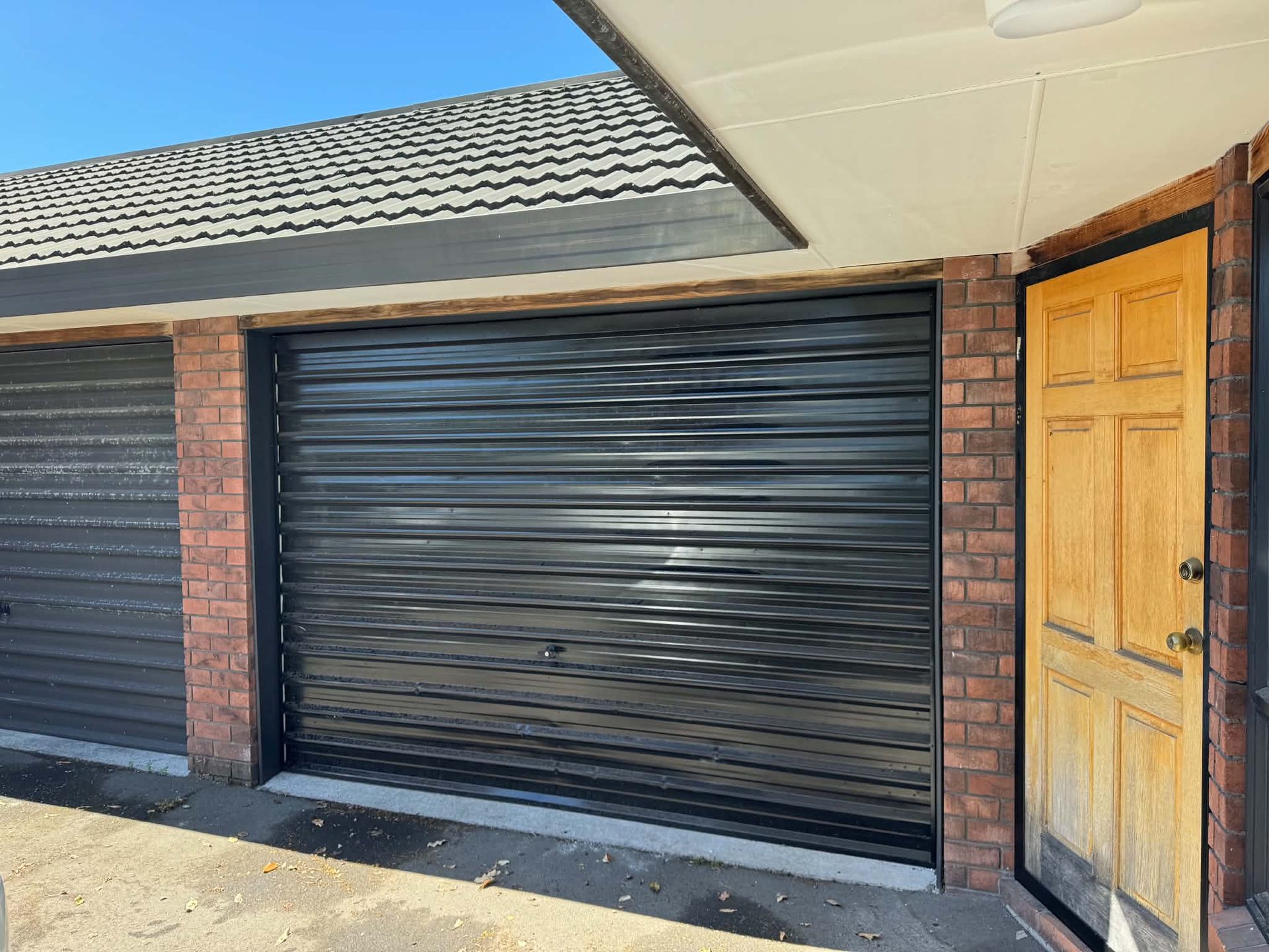 Graphite garage door refinish with brick surround, Addington